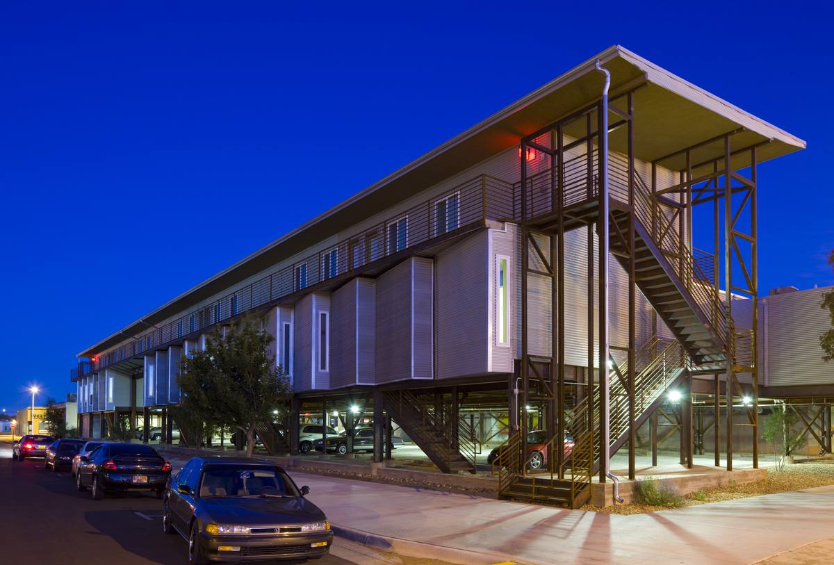 The new building at Hotel Clovis Lofts at dusk with its exterior stair tower