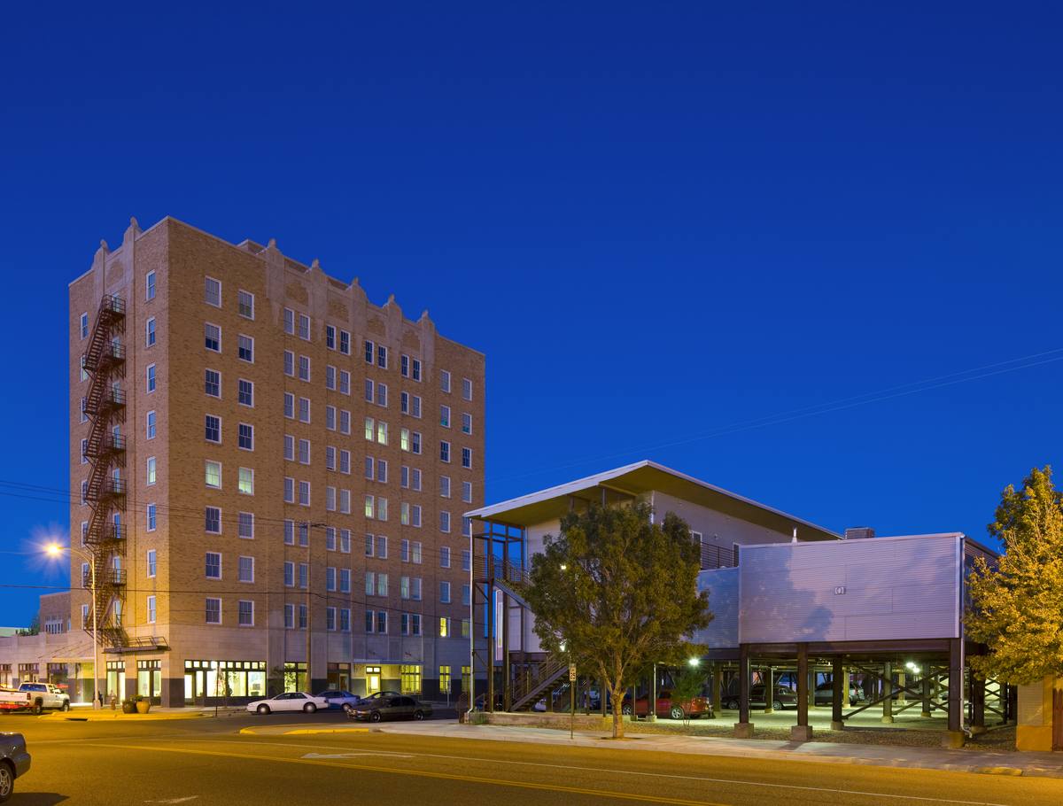 Hotel Clovis Lofts at dusk: the 1929 tower and the new building along Main Street in Clovis, New Mexico