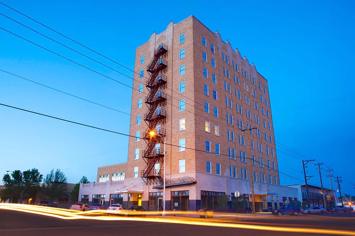 Hotel Clovis Lofts at night with street lights and passing traffic on Main Street